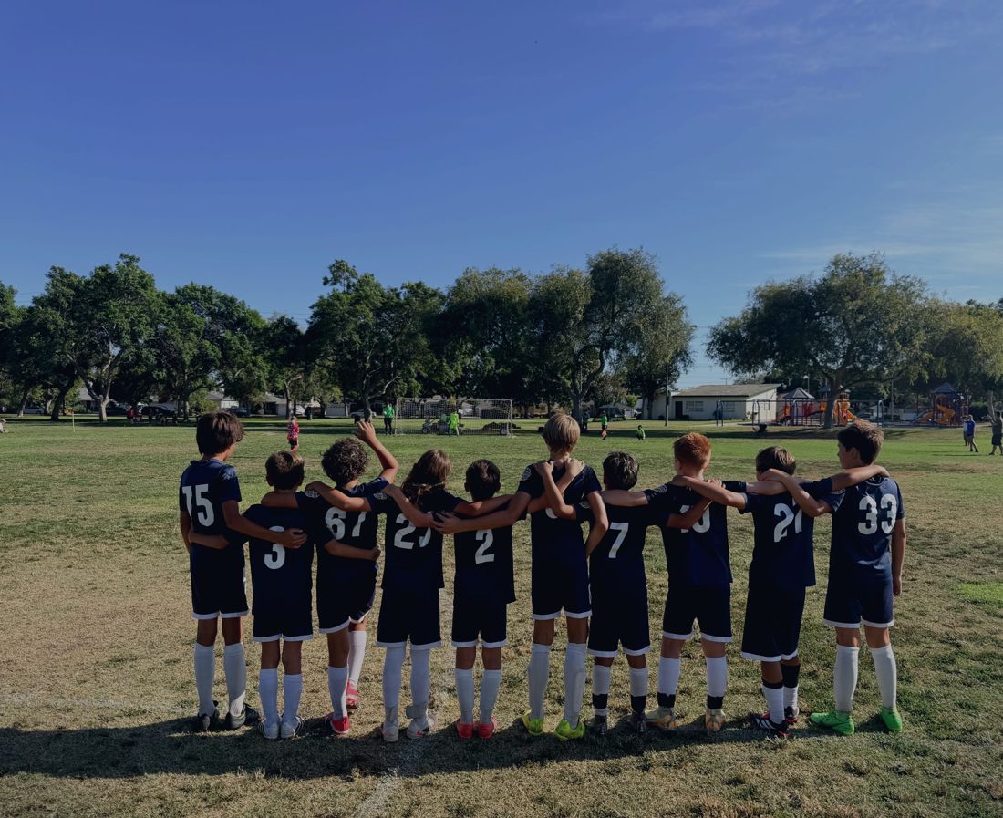 AYSO Region 84 Extra Play Boys 11U team, arms over shoulders, facing the field