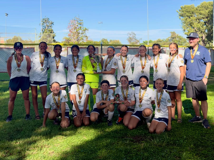 AYSO Region 84 Extra Play team with tournament medals at golden hour in Mission Viejo